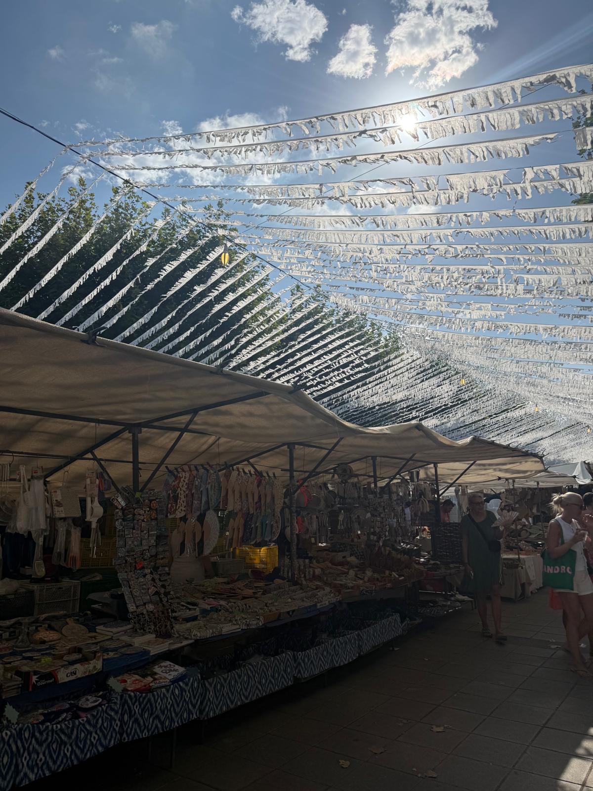 Marktstände unter Sonnensegeln und Festgirlanden in Artà