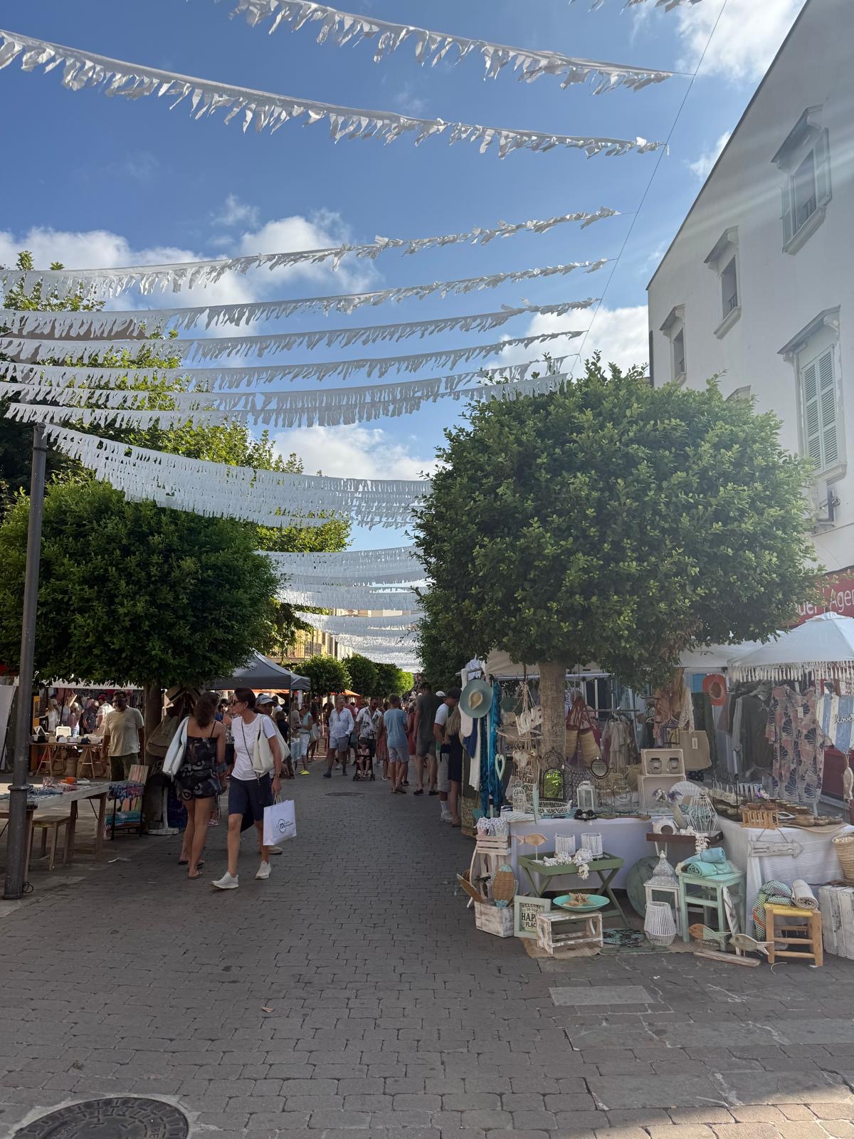 Marktgasse mit weißen Girlanden und Ständen im Zentrum von Artà
