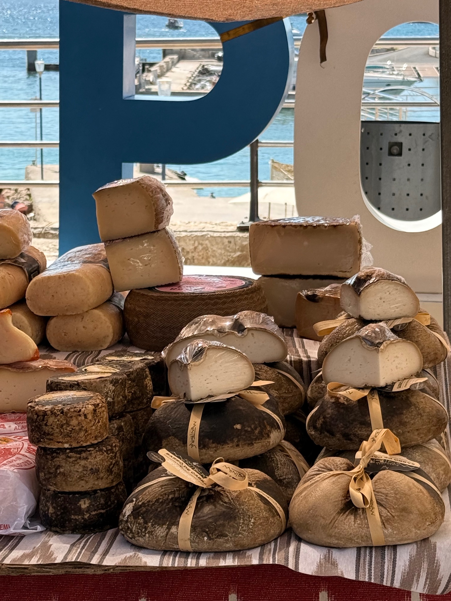 Käsestand mit mallorquinischem Ziegenkäse mit Blick auf den Hafen