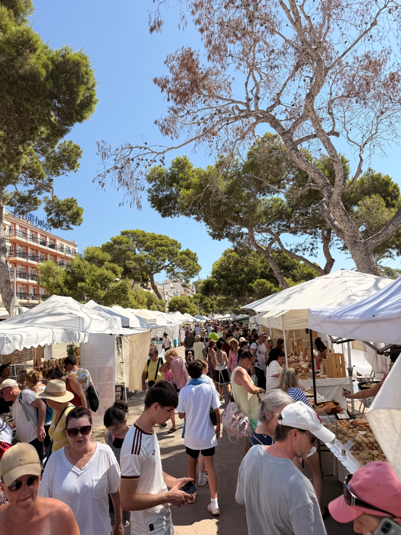 Marktgasse mit weißen Pavillons und Bäckerstand in Porto Cristo